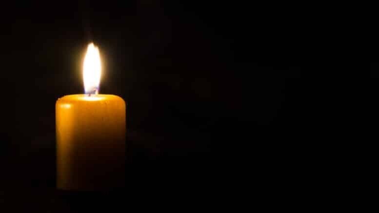 one burning candle decoration against black background